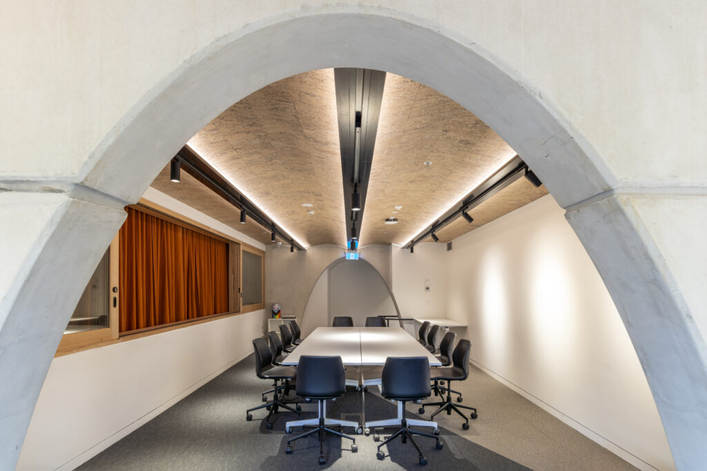 Mezzanine Room captured from the window, displaying egg shaped walkways, table and chairs and window/curtain on the left wall