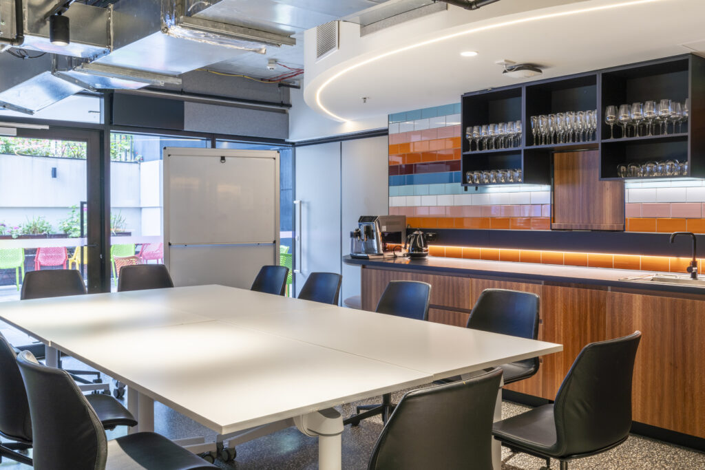 Boardrom; table with chairs but the kitchenette and whiteboard is behind