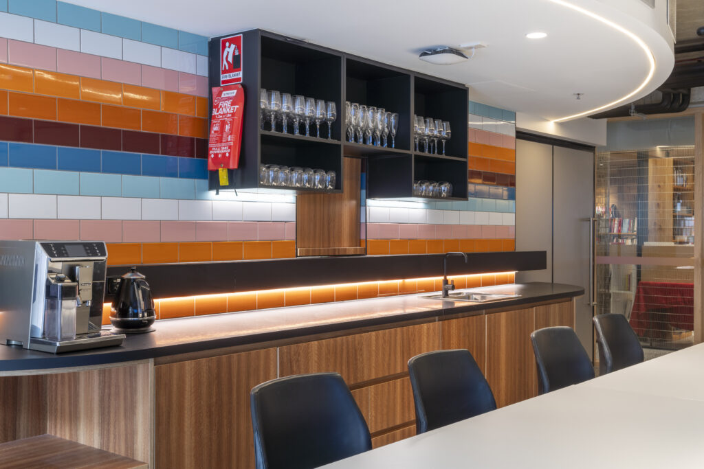 Boardroom Kitchenette with table and chairs. Coffee station, cupboards, multicoloured tiles