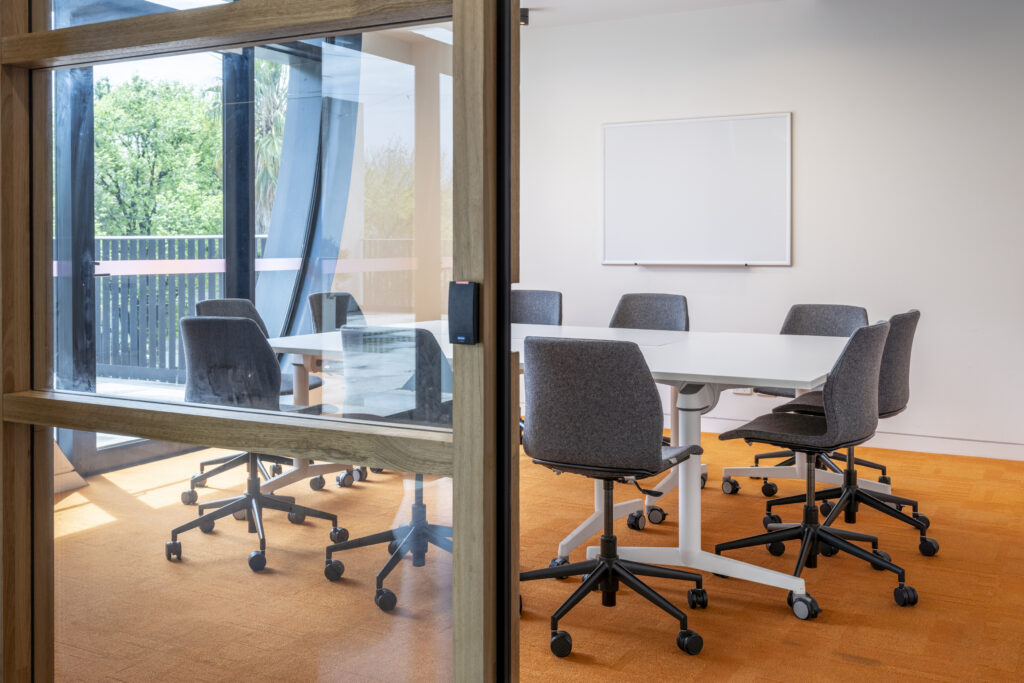 Meeting Room 4 with chairs and tables captured through a glass door