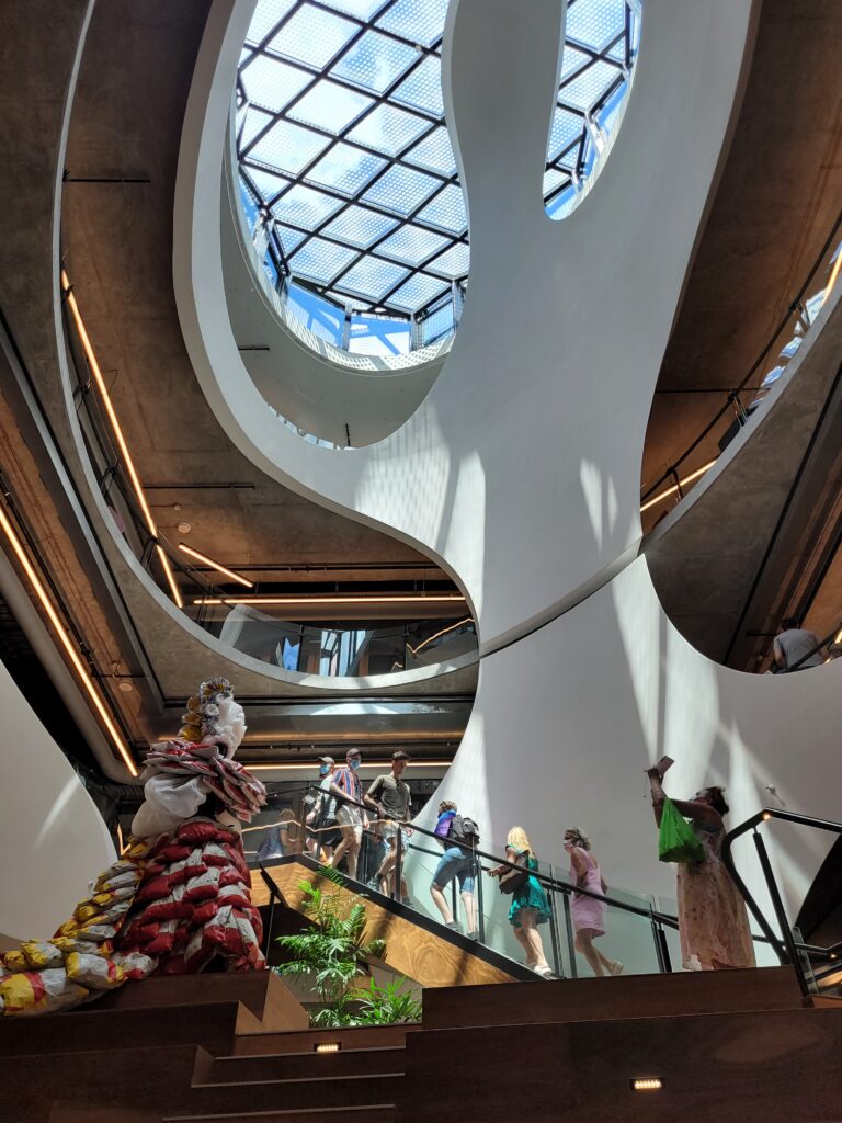 People walking up stairs in light-filled Atrium of the Pride Centre