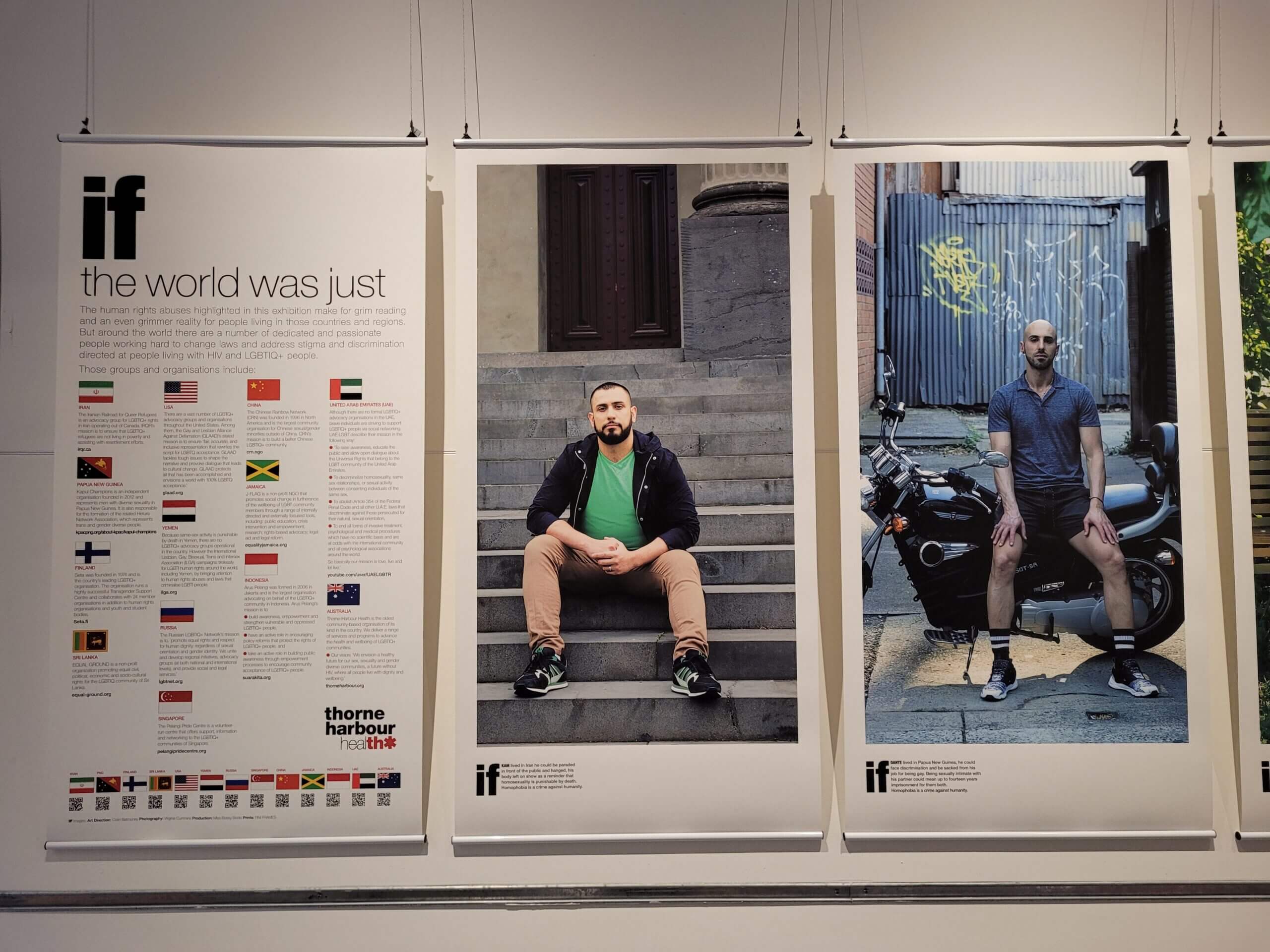 photo of portraits featuring masculine-presenting people sitting, hanging on a wall in a gallery space