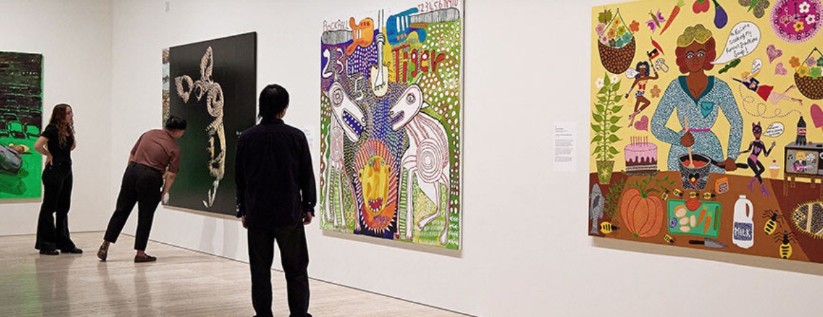 three people stare at a large artwork in an exhibition gallery