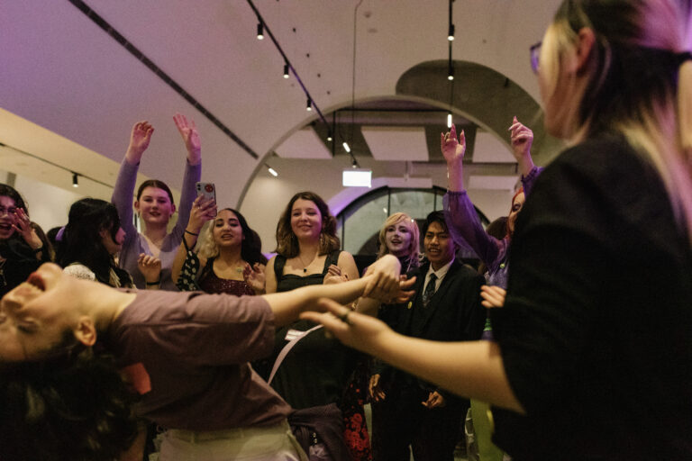 A group of people dancing. One person leands backwards towards the camera.