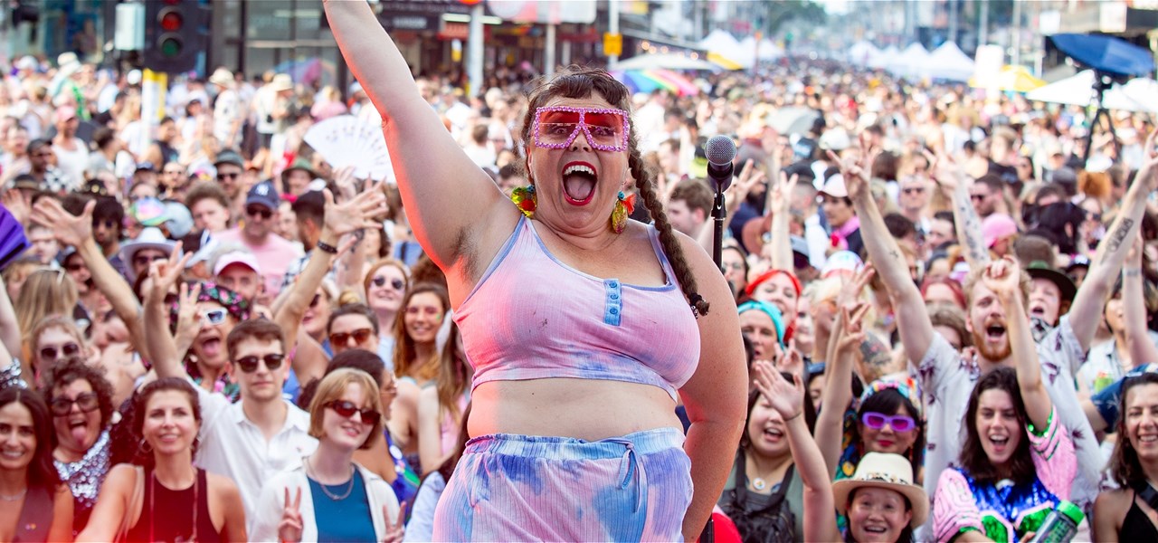 Person standing on stage with the crowd in the background