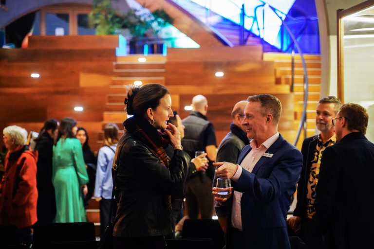 Two people standing in a crowd talking