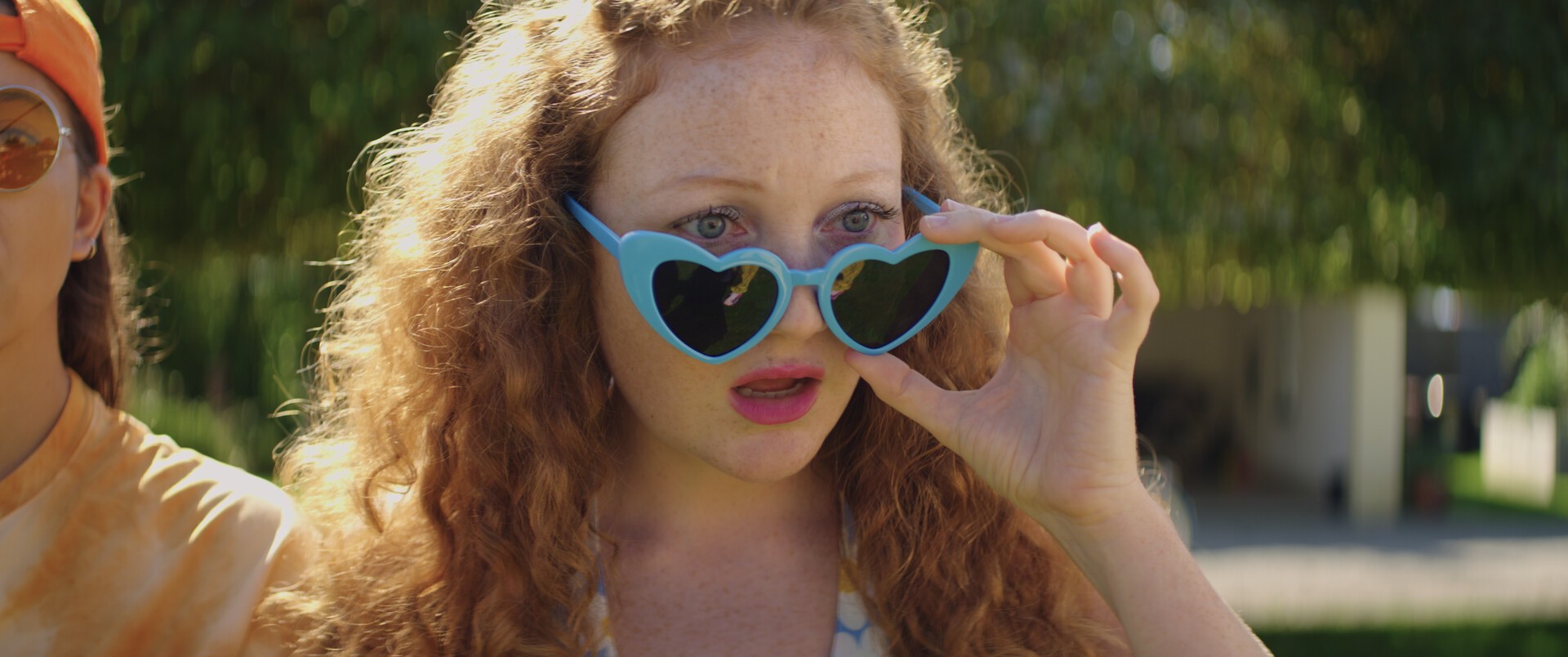 A person with heart shaped glasses stares with disbelief
