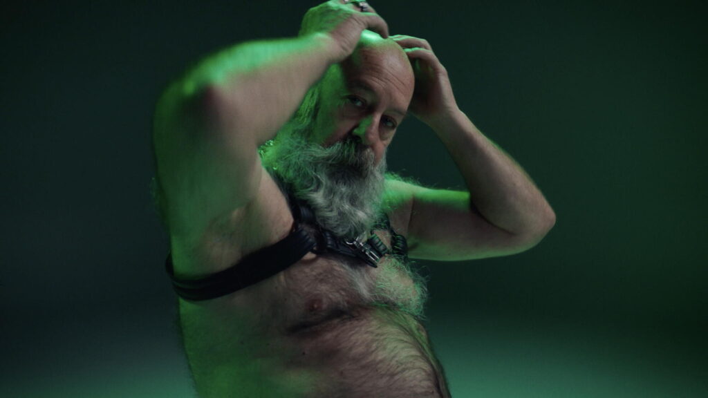 male presenting person in a Harness